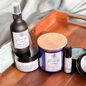 Peut inclure: Un ensemble de produits de bain et de corps parfum&eacute;s &agrave; la lavande et &agrave; la lime. L'ensemble comprend une bougie, un spray d'ambiance, un beurre corporel, une huile essentielle en bille et un savon. Tous les produits portent la m&ecirc;me &eacute;tiquette avec le texte "Reading Nook" en &eacute;criture cursive.