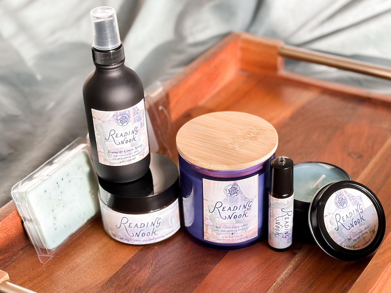 Peut inclure: Un ensemble de produits de bain et de corps parfum&eacute;s &agrave; la lavande et &agrave; la lime. L'ensemble comprend une bougie, un spray d'ambiance, un beurre corporel, une huile essentielle en bille et un savon. Tous les produits portent la m&ecirc;me &eacute;tiquette avec le texte "Reading Nook" en &eacute;criture cursive.