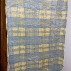 May include: A yellow and blue plaid blanket with a soft, fuzzy texture.