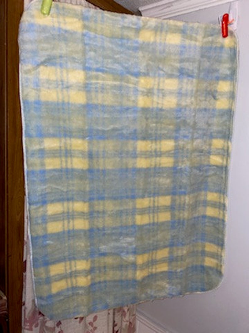 May include: A yellow and blue plaid blanket with a soft, fuzzy texture.