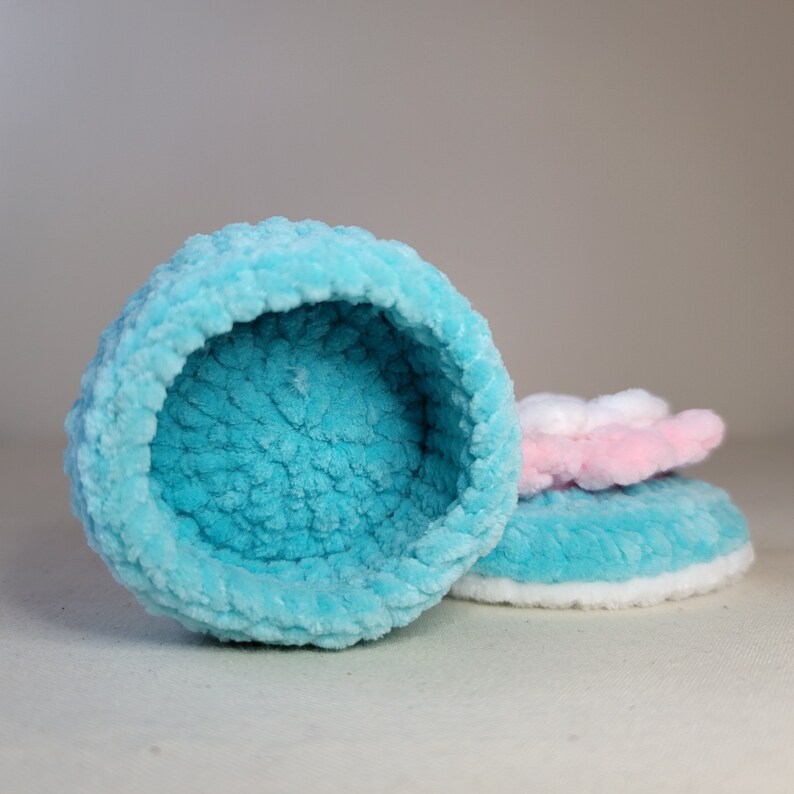 May include: A blue and white plush pet bed with a soft, fluffy texture. The bed is shaped like a bowl and has a white rim.
