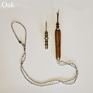 Puede incluir: Dos abreojales de costura con mangos de madera y detalles metálicos. Un abreojales tiene una cadena plateada adjunta. La palabra "Oak" está en la esquina superior izquierda.