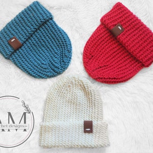May include: Three crocheted beanies in different colors: teal, red, and cream. Each beanie has a brown leather patch on the side.