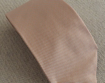 May include: A brown and white patterned silk tie. The tie has a subtle geometric design.