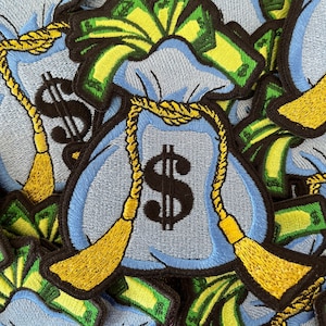 May include: A close-up of several blue money bags with yellow rope ties and dollar signs. The bags are filled with green paper money.