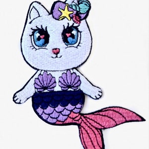 May include: White cat mermaid with pink, purple, and blue scales, wearing a seashell bra and a crown of seashells and a star.