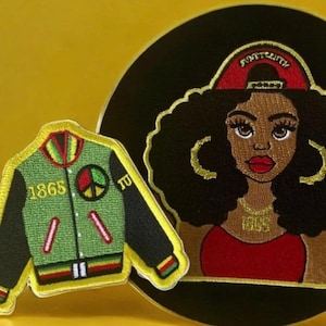 May include: Two embroidered patches. One is a green, black, and red bomber jacket with the year 1865 and a peace sign. The other is a black woman with a red shirt and a gold chain with the year 1865 on it. The woman is wearing a red and gold hat that says "Sixteenth".