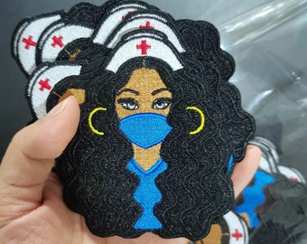 May include: An embroidered patch depicting a cartoon nurse with curly black hair, wearing a blue surgical mask, a white nurse's cap with a red cross, and gold hoop earrings.