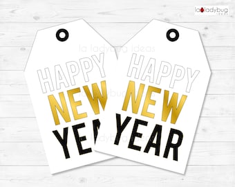 Può includere: Due etichette regalo bianche con lettere nere e dorate. Le etichette dicono "Happy New Year" con la parola "New" in oro e le parole "Happy" e "Year" in nero.