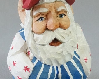 Christmas figure, Hand Carved Original, Santa Claus, Squatty Santa in Green Overalls Hands His Pocket Red Ball Cap SA100 4.5” X 2.5” X 2.5”