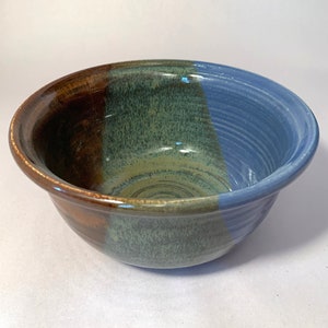 May include: A ceramic bowl with a brown, green, and blue glaze. The bowl is hand-thrown and has a unique, rustic look.
