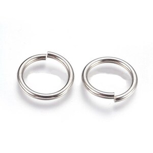 May include: Two silver-toned metal jump rings, each featuring a circular shape with a single clean cut opening. The rings have a smooth, polished surface and a consistent thickness, designed as circular connectors for jewellery making and craft projects.