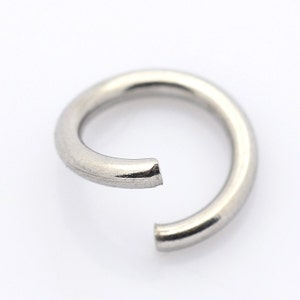 May include: A silver jump ring, a small metal ring used for connecting jewelry components.