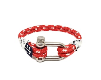 Puede incluir: Pulsera de temática náutica con diseño de cuerda roja y blanca. Cuenta con un cierre de grillete de acero inoxidable y un acento azul marino con un símbolo de ancla blanco. La pulsera está diseñada para una muñeca de aproximadamente 17.8 cm.