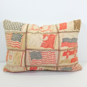 May include: A rectangular pillow with a patchwork design featuring various flags, including the American flag, in red, white, and blue.