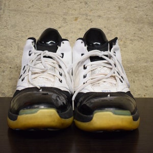 Peut inclure: Une paire de chaussures de basket-ball blanches et noires avec des lacets noirs et une semelle jaune.