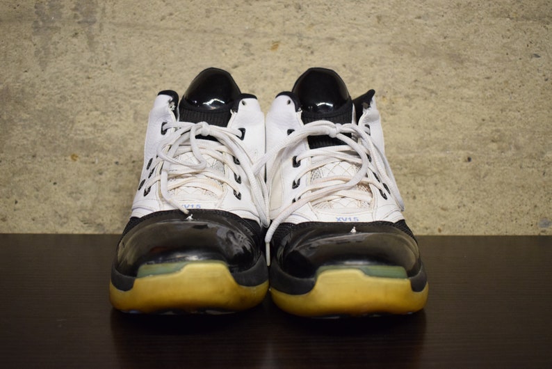 Peut inclure: Une paire de chaussures de basket-ball blanches et noires avec des lacets noirs et une semelle jaune.
