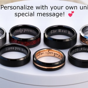 May include: Eight different black, silver, and rose gold wedding bands with various engravings. The engravings include "you & me forever", "Pinky promise", "I love you more", "The Real King", "Always and Forever", "20-23 Always & Forever", "and me, I love you so much".