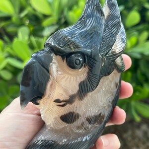 Pode incluir: Uma figura de coruja esculpida em &aacute;gata preta e branca. A coruja tem um rosto detalhado com um olho grande e um bico. A figura tem aproximadamente 12,5 cm de altura.