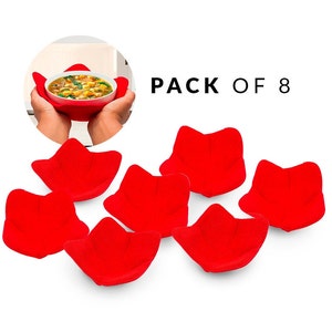 May include: A pack of eight red bowl cozies. The image shows a person holding a bowl of soup in a red cozy. The text "PACK OF 8" is displayed in black. The bowl cozies are made of a soft, plush material.