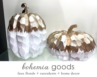 May include: Two faceted pumpkin decorations with a metallic gold top and a matte white bottom. The pumpkins feature a carved, geometric texture. Below the pumpkins, the text reads: bohemia goods, faux florals + succulents + home decor.