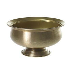 May include: A gold-colored metal bowl with a rounded body and a flared rim. The bowl sits on a short, pedestal base. The interior of the bowl is a slightly darker shade of gold. The bowl is likely for decorative or functional use.