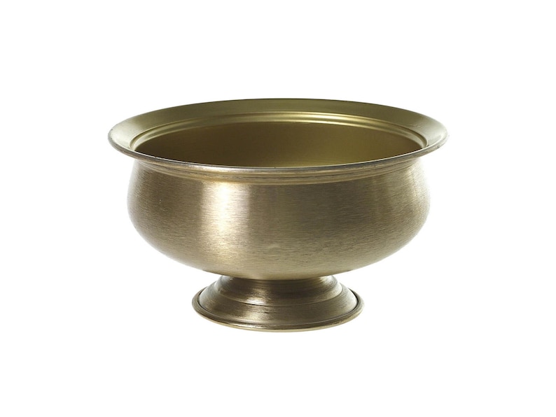 May include: A gold-colored metal bowl with a rounded body and a flared rim. The bowl sits on a short, pedestal base. The interior of the bowl is a slightly darker shade of gold. The bowl is likely for decorative or functional use.