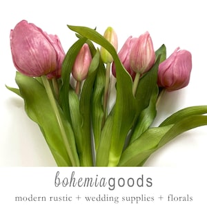 May include: A bouquet of pink tulips with green stems and leaves. The tulips are arranged in a loose, natural style. The image is taken from a high angle, showing the entire bouquet.