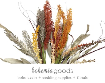 May include: A bouquet of dried grasses and branches in shades of brown, gold, and rust. The bouquet is arranged in a vase and is perfect for adding a touch of natural beauty to any room.