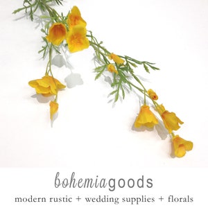 May include: A sprig of yellow artificial flowers with green stems and leaves. The flowers are arranged in a cascading pattern. The background is white. The text "bohemia goods" is written in cursive below the flowers. The text "modern rustic + wedding supplies + florals" is written below the text "bohemia goods".