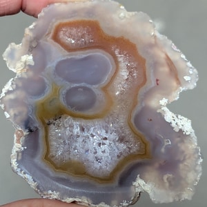 Calming Laguna Agate features  lavender and sunset orange banding and crystalline center. Hand polished in Sedona, Arizona