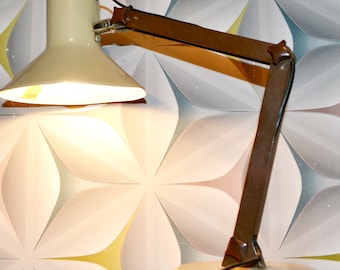 May include: A vintage desk lamp with a beige shade and a brown adjustable arm. The lamp has a round base and a cord.