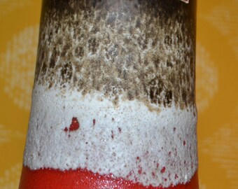 May include: A brown, white, and red ceramic vase with a speckled glaze. The vase has a label that reads "scheurich".