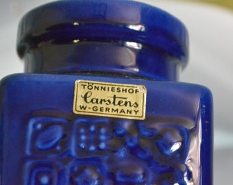 May include: A cobalt blue ceramic jar with a gold label that reads "Tonnieshop Carstens W-Germany". The jar has a textured surface with a geometric pattern.