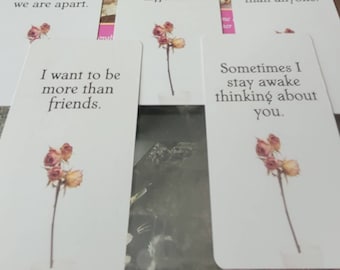 May include: Four cards with a floral design and romantic text. The cards read "we are apart", "I want to be more than friends", "Sometimes I stay awake thinking about you", and "cal".