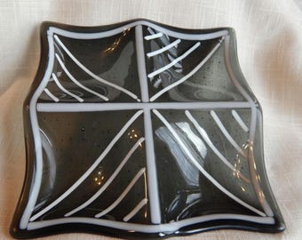 Square transparent black with white stringer patterns on the four wells.  6.25 x 6.25 inches