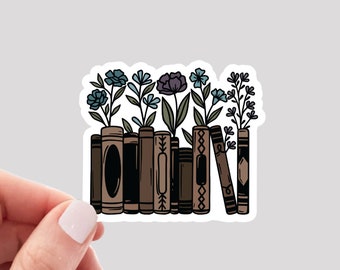 May include: A sticker featuring a row of brown books with flowers growing out of them. The flowers are blue and purple, with green stems and leaves. The books have various designs.