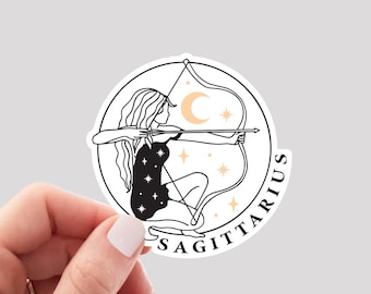 May include: A white sticker with a black line drawing of a woman with a bow and arrow. The woman is wearing a star-patterned dress. The sticker has the word "SAGITTARIUS" written around the edge.