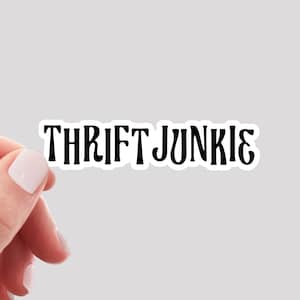May include: A black and white sticker with the text "Thrift Junkie" in a stylized font.