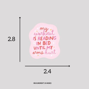 May include: Pink sticker with the text "my workout is reading in bed until my arms hurt" in pink and white lettering with gold stars.