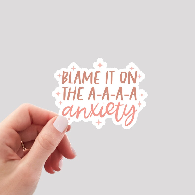 Puede incluir: Pegatina rosa y blanca con el texto "Blame it on the a-a-a-a anxiety" con peque&ntilde;as estrellas alrededor del texto.