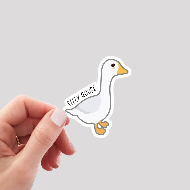 May include: White goose sticker with the text "Silly Goose" on the back. The goose has a yellow beak and feet.