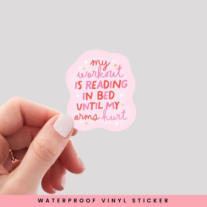 May include: Pink and white sticker with the text "my workout is reading in bed until my arms hurt" with gold stars.