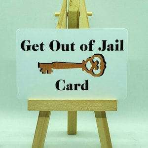 May include: A white card with black text that reads "Get Out of Jail Card" and a brown key illustration.