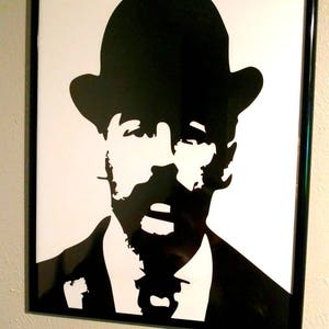 May include: Black and white silhouette of a person wearing a hat and a suit. The person has a mustache and beard.