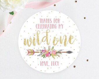 May include: Round white sticker with pink and gold glitter accents. The sticker says "Thanks for celebrating my wild one. Love, Lucy".