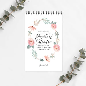 May include: A white card with a floral wreath design and the text "TWELVE MONTH Perpetual Calendar FOR BIRTHDAYS, ANNIVERSARIES, AND SPECIAL DATES Genne & C"