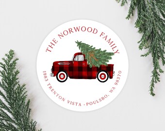 May include: Red and black plaid truck with a Christmas tree in the back. The truck is on a white circle with the text "THE NORWOOD FAMILY 1983 TRENTON VISTA  POULSBO, WA 98370".
