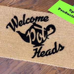 May include: A brown coir doormat with black text that reads "Welcome Tea Heads" and a black silhouette of a teapot.