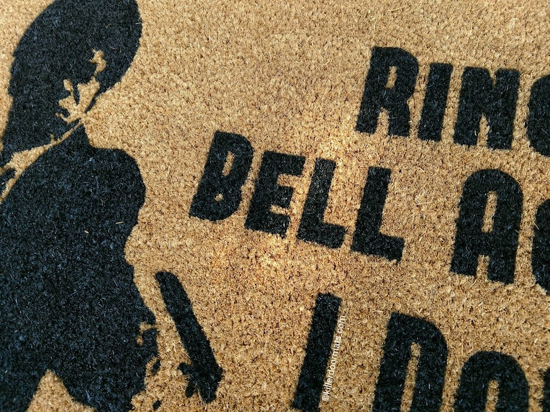 May include: A brown coir doormat with the text "Ring the bell and I'll come" in black lettering. A silhouette of a person is in the top left corner of the mat.
